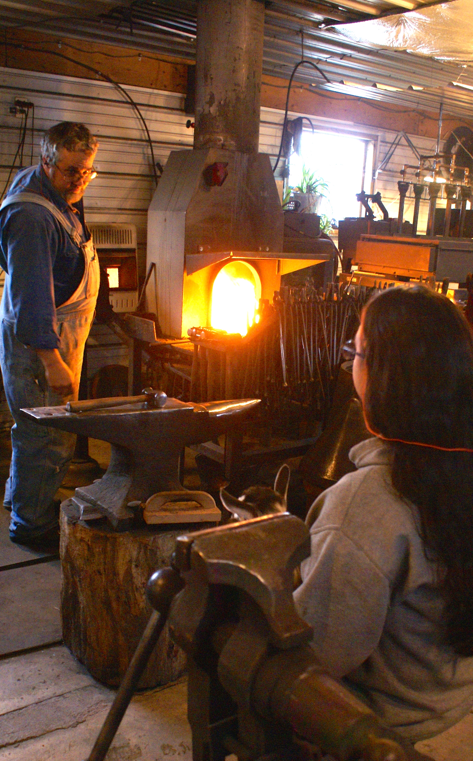 Doug and Danielle talk over the day's work while the forge warms to working temperatures.