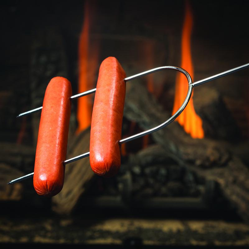 Hot dog roasting fork in front of fire