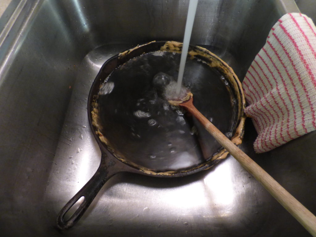 Skillet in sink, adding hot water. The remnants of candy melt off almost immediately. Very little scrubbing needed.