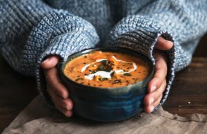 hands holding bowl of soup