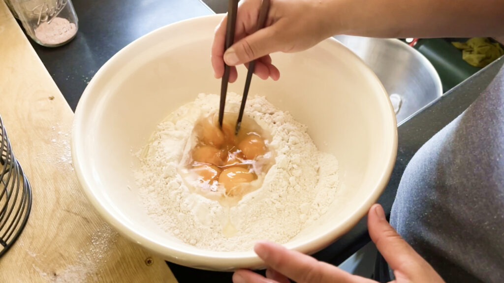 mixing the eggs into flour