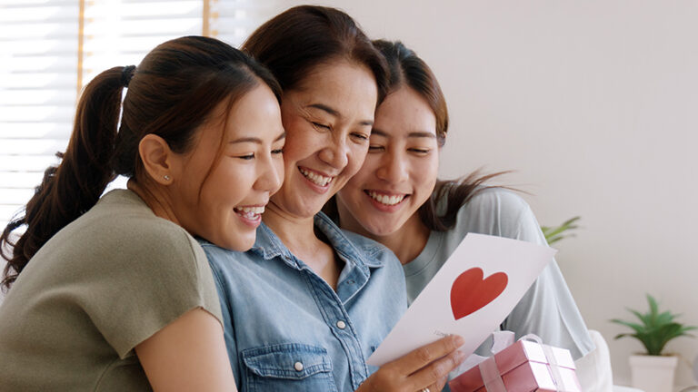 mother and daughters with card