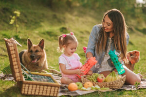 mother, daughter and dog on a picnic