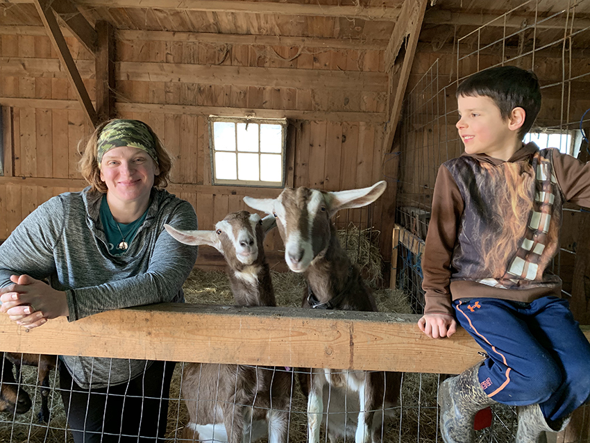 family with goats in barn