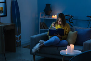 Woman reading with flashlight during power outages