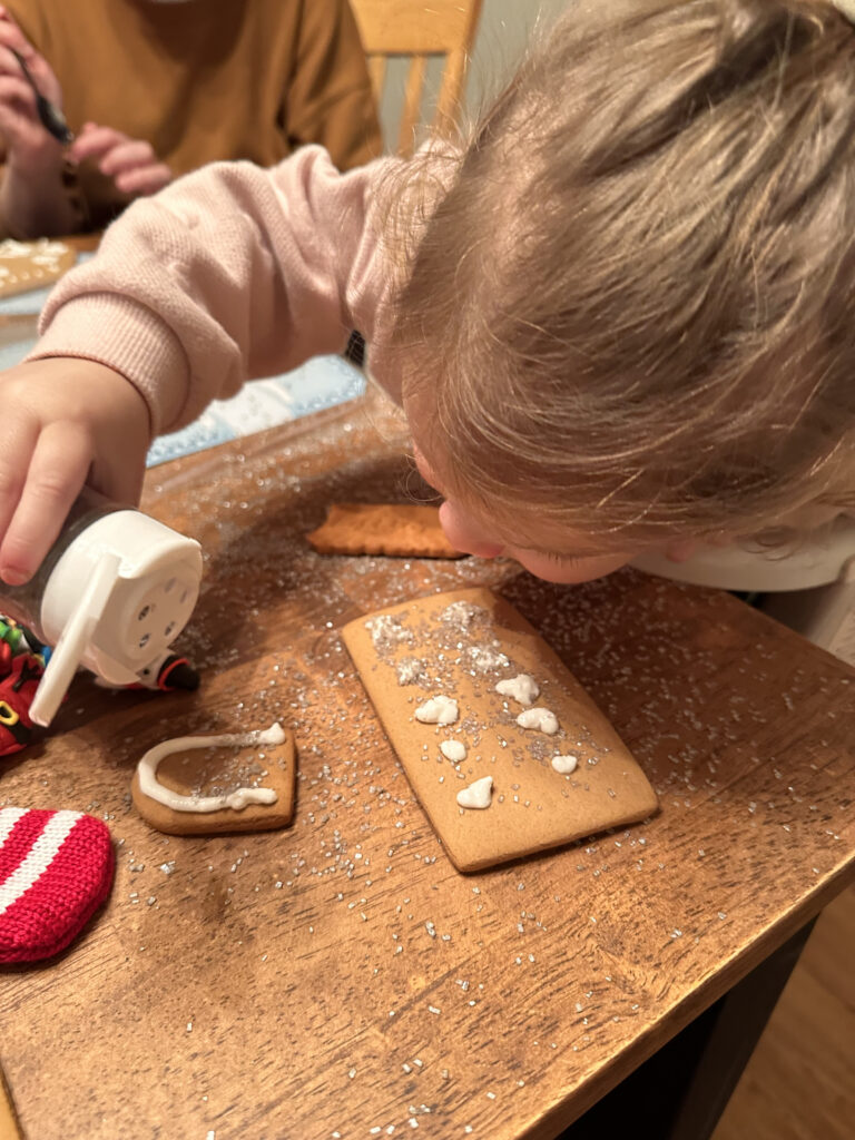 Adding more glitter to gingerbread house