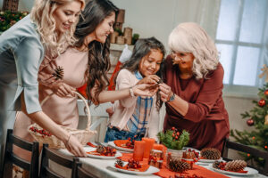 Child decorating a holiday table with women