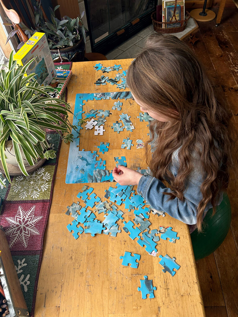 Child putting together jigsaw puzzle