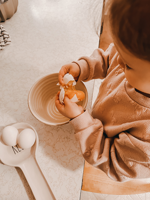 Child cracking egg into the bowl