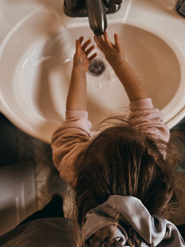 Child washing hands after baking