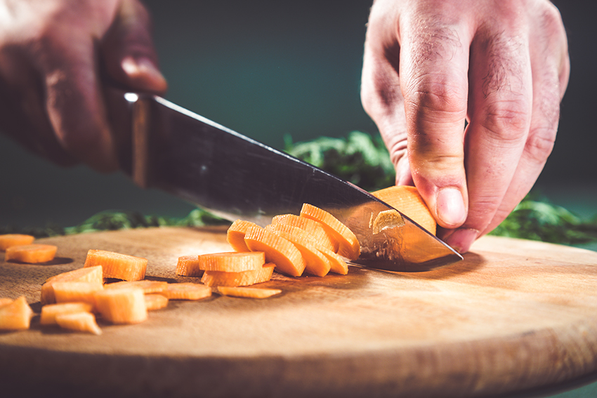 Chopping carrots on cutting board