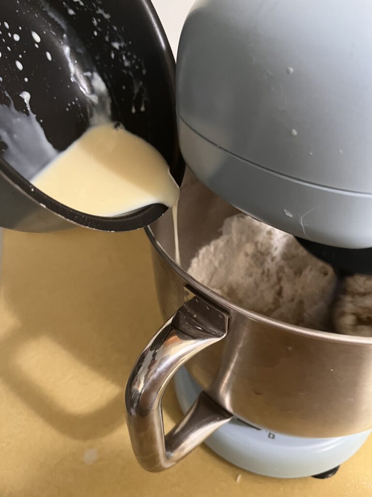 Pouring ingredients in bowl of stand mixer