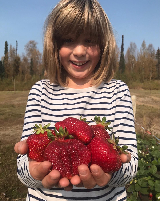 Girl holding homegrown strawberries