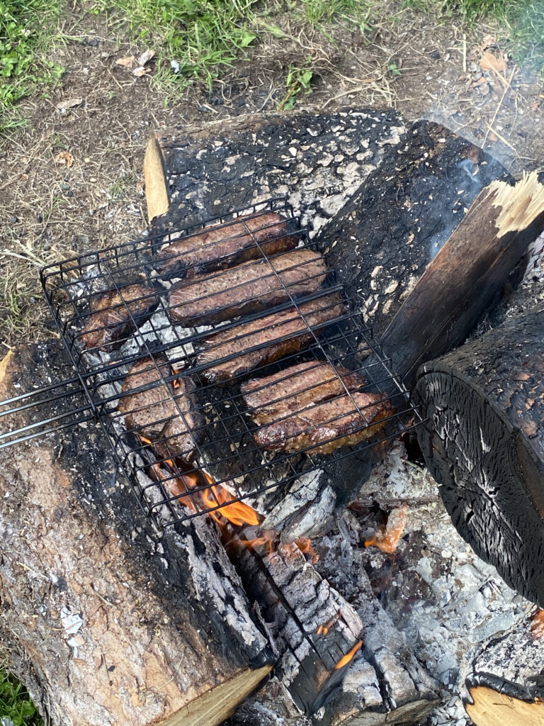 Cooking steaks over campfire