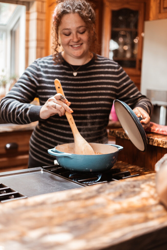 Woman cooking with enameled cast iron Dutch Oven on stove