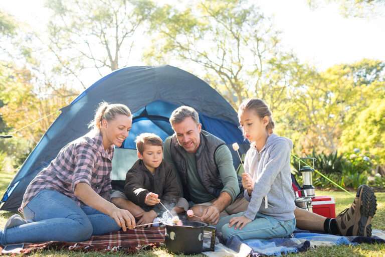 family camping in tent and roasting marshmallows