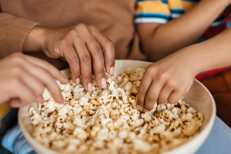 hands in popcorn bowl