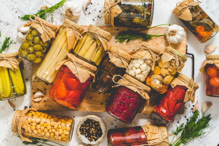 Stocking pantry with a variety of preserved food in jars