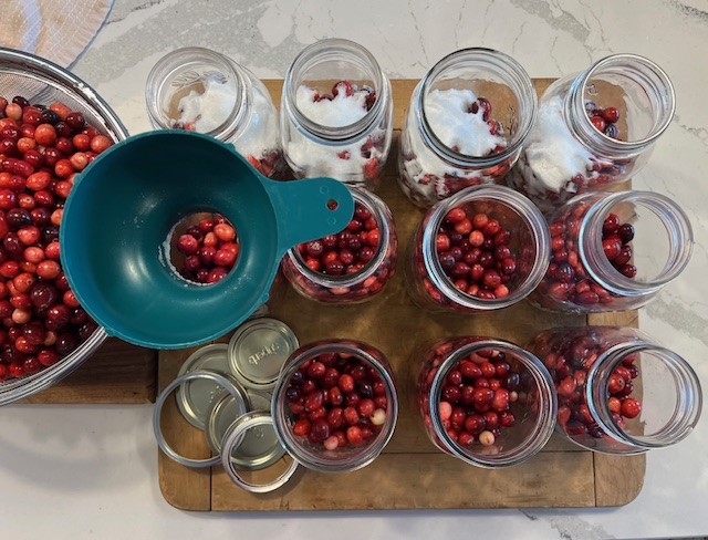 Canning jars filled with fresh cranberries