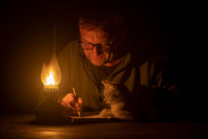 Man with oil lamp and cat