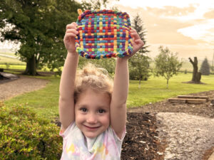 child with DIY potholder 
